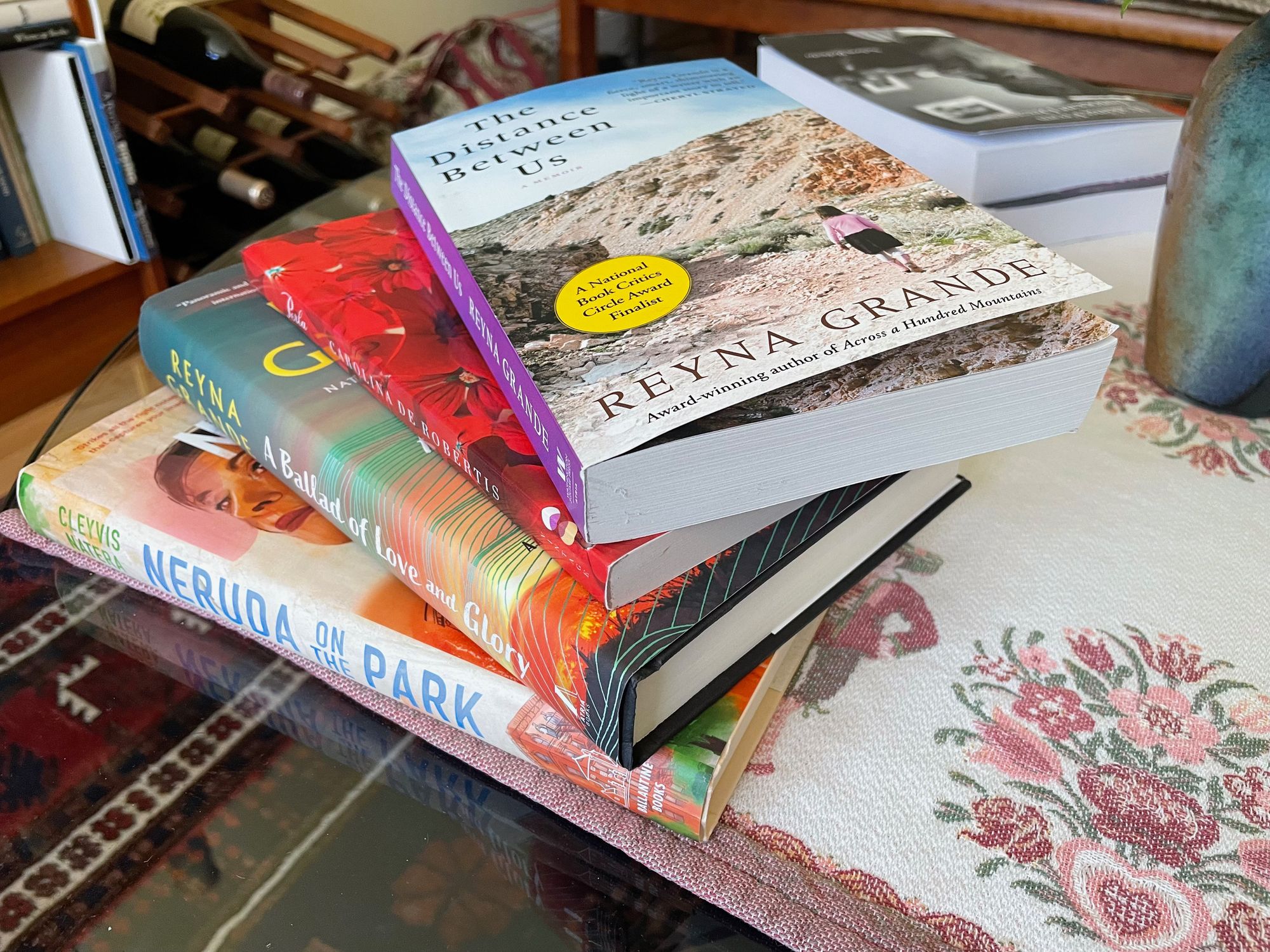 A stack of books on a glass coffee table